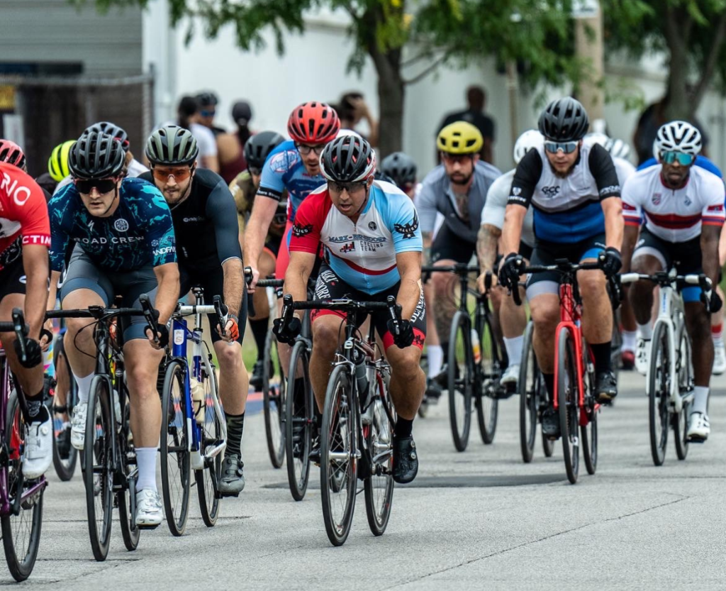 The cyclists wear matching, vividly colored jerseys and are intensely focused as they navigate a challenging course.